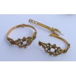 Two gilt bangles engraved with flowers. Approx. 28