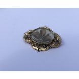 A large gold mounted mourning brooch with oval hai