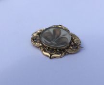 A large gold mounted mourning brooch with oval hai