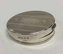 A modern circular silver hinged top compact with v