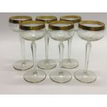 A set of six tall glass and gilded champagne flute