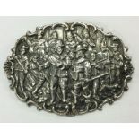 A cast silver brooch decorated with figures and sc