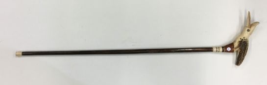 An unusual tapering walking stick carved with a bi