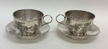 A pair of unusual Chinese silver cups and saucers