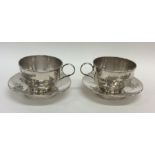 A pair of unusual Chinese silver cups and saucers