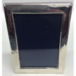 A modern rectangular silver picture frame with vel