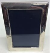 A modern rectangular silver picture frame with vel