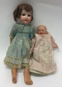 A porcelain headed doll together with one other. E