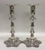 A pair of tall silver Georgian style candlesticks