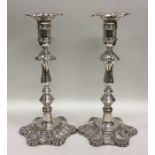 A pair of tall silver Georgian style candlesticks