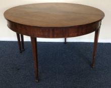 An Antique mahogany circular dining table on taper