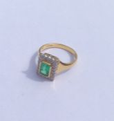 An emerald and diamond rectangular cluster ring in