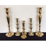 A pair of tall brass candlesticks together with tw