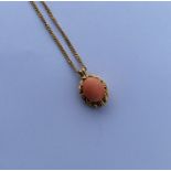 A heavy 18 carat coral pendant on fine link chain.