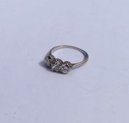 A diamond three stone ring in platinum claw mount.