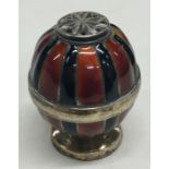 An unusual silver and enamel pepper with gilt inte
