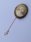 An oval cameo of a lady's head in gold frame. Appr