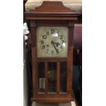 An oak cased wall clock with silvered dial. Est. £