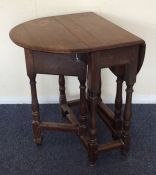 An Antique oak drop leaf table on turned legs. Est