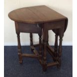 An Antique oak drop leaf table on turned legs. Est