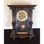 An Edwardian mahogany wall clock with brass dial.
