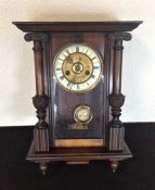 An Edwardian mahogany wall clock with brass dial.