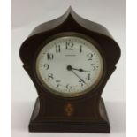 A small Edwardian mahogany mantle clock with white