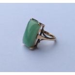 A gold and jade single stone ring in claw mount. A