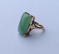A gold and jade single stone ring in claw mount. A