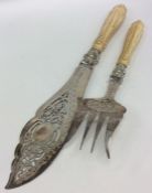 A pair of silver bladed fish servers with pierced