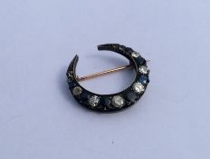A sapphire and diamond crescent brooch mounted in