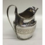 A Georgian silver bright cut cream jug with swirl