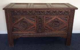 An Antique hinged top coffer with carved decoratio