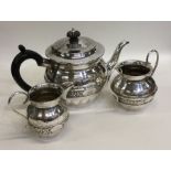 A stylish silver three piece tea service decorated