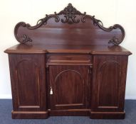 A mahogany three drawer sideboard with scroll deco