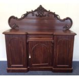 A mahogany three drawer sideboard with scroll deco