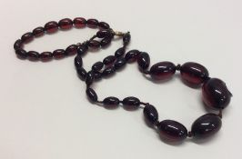 A tapering string of red amber beads together with