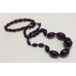 A tapering string of red amber beads together with