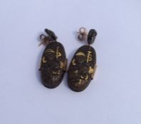 A pair of Shakudo oval earrings with gold mounts.
