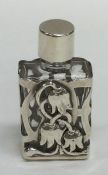 A small pierced silver perfume bottle decorated wi