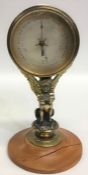 An unusual brass mounted barometer with silvered d