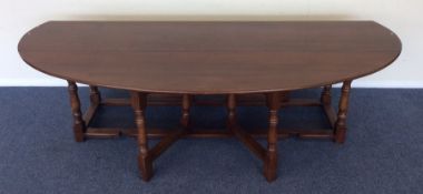 A massive oak drop leaf table on turned supports.