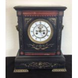 A large slate mantle clock decorated with gilding.