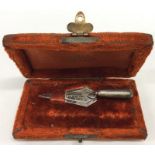 A cased silver bookmark in the form of a trowel. B