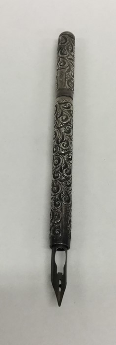 An embossed silver quill decorated with scrolls an