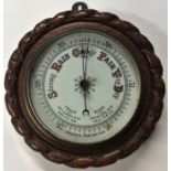 A carved oak aneroid barometer. Est. £20 - £30.