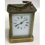 A brass mounted small carriage clock with white en