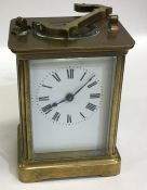 A brass mounted small carriage clock with white en
