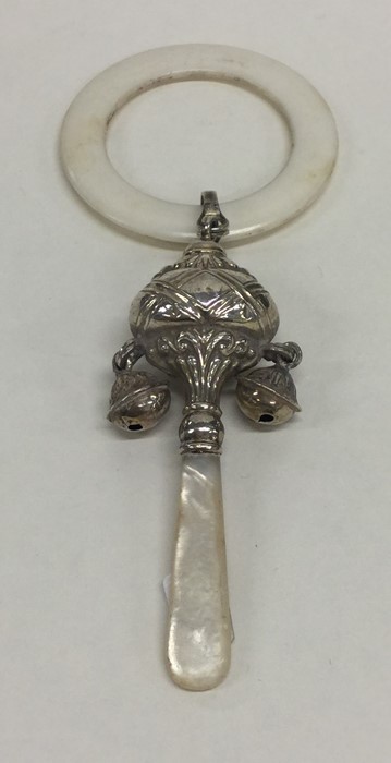 A silver teether/rattle decorated with bells and f