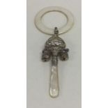 A silver teether/rattle decorated with bells and f